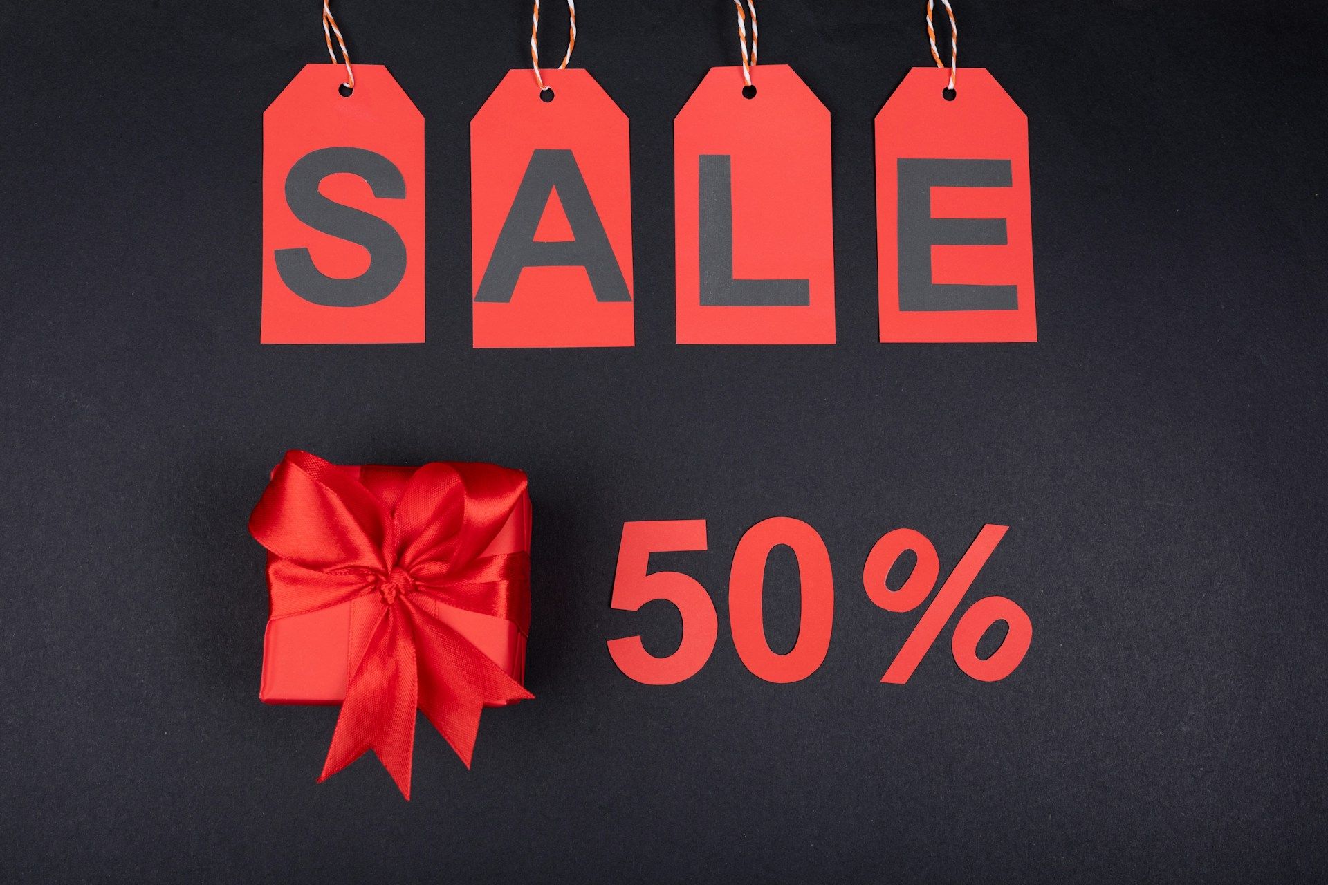 Black Friday Super Sale, black background, red letters saying "Sale", red present, red tect 50%